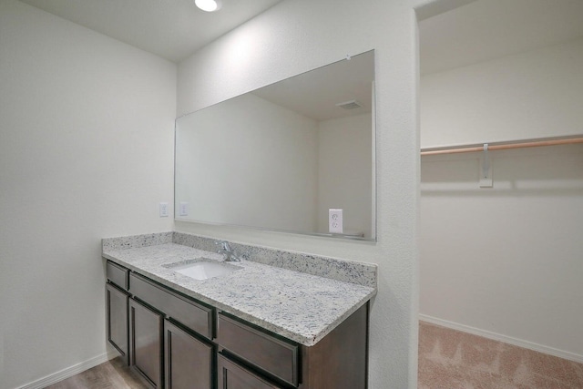 bathroom featuring visible vents, vanity, and baseboards