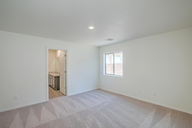 empty room featuring light colored carpet, visible vents, baseboards, and recessed lighting