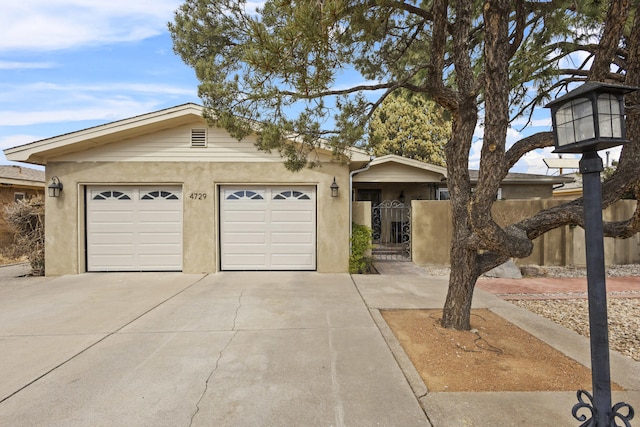 single story home featuring concrete driveway, fence, an attached garage, and a gate