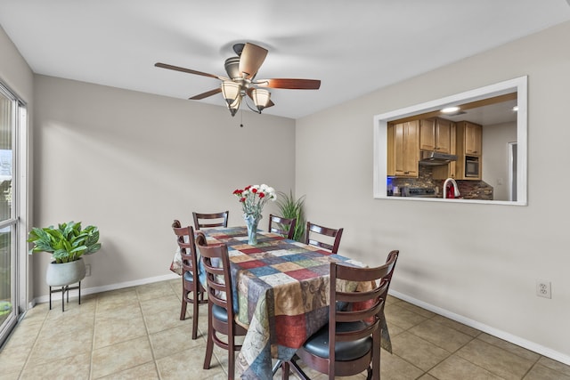 dining room featuring a ceiling fan, light tile patterned flooring, and baseboards