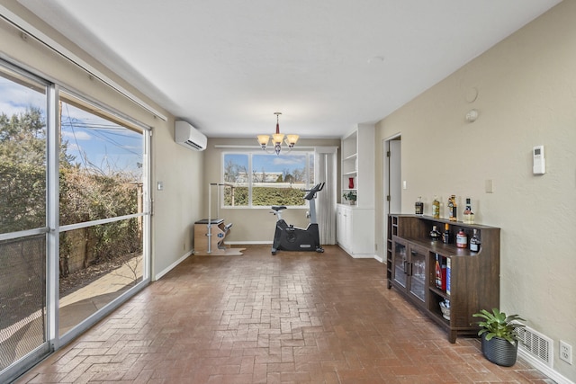 dining room featuring brick floor, baseboards, an inviting chandelier, and a wall mounted air conditioner