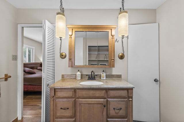 ensuite bathroom featuring ensuite bathroom, wood finished floors, and vanity