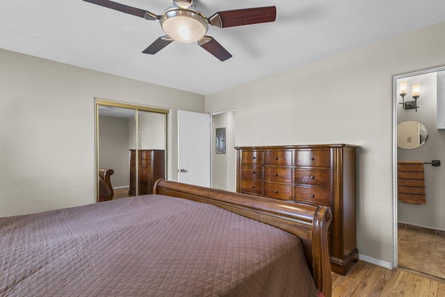 bedroom featuring a ceiling fan, a closet, baseboards, and wood finished floors