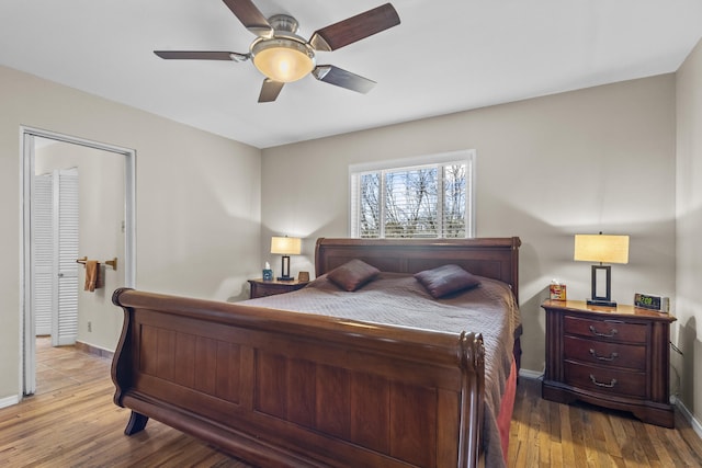 bedroom featuring ceiling fan, baseboards, and wood finished floors