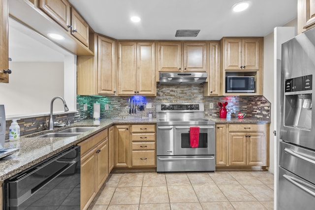 kitchen with light stone counters, stainless steel appliances, decorative backsplash, a sink, and under cabinet range hood