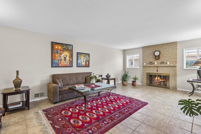 tiled living area with baseboards, a fireplace, and visible vents