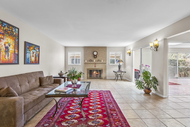 living area with a fireplace, baseboards, and light tile patterned flooring