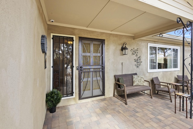 doorway to property featuring a patio and stucco siding