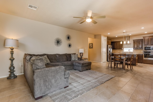 living area with a ceiling fan, recessed lighting, visible vents, and baseboards