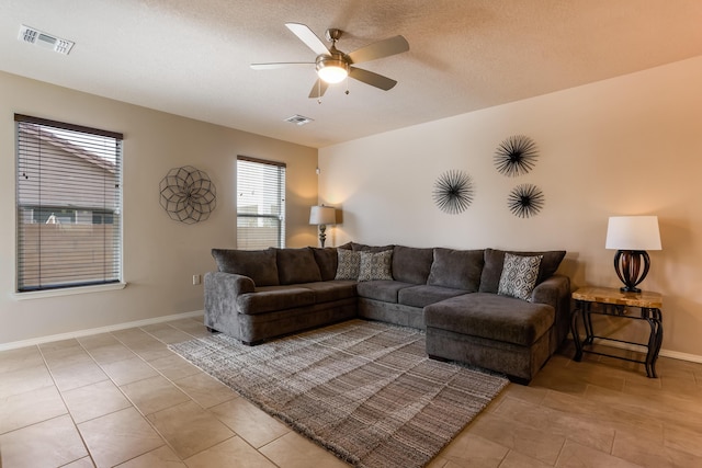 living room with visible vents, ceiling fan, baseboards, and light tile patterned floors