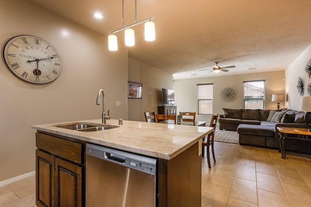 kitchen featuring a ceiling fan, dishwasher, open floor plan, a kitchen island with sink, and a sink