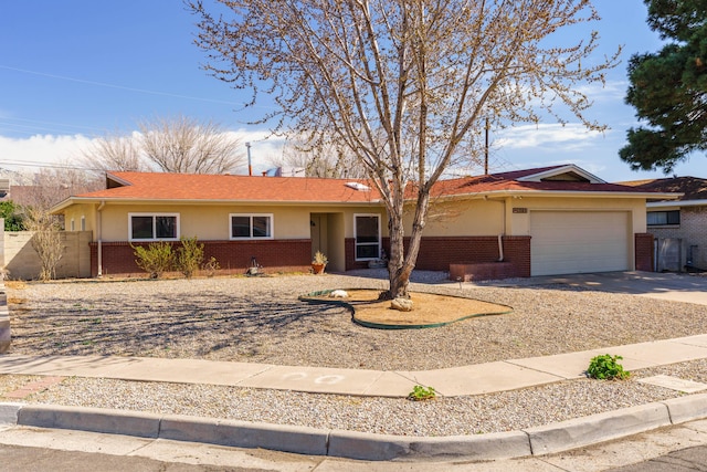 ranch-style house featuring brick siding, concrete driveway, a garage, and fence