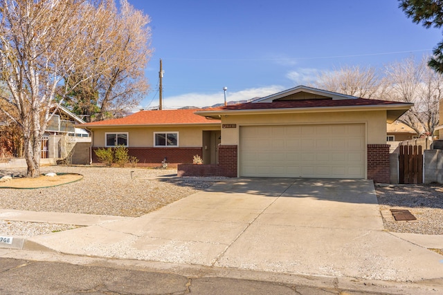 ranch-style home featuring fence, stucco siding, concrete driveway, a garage, and brick siding