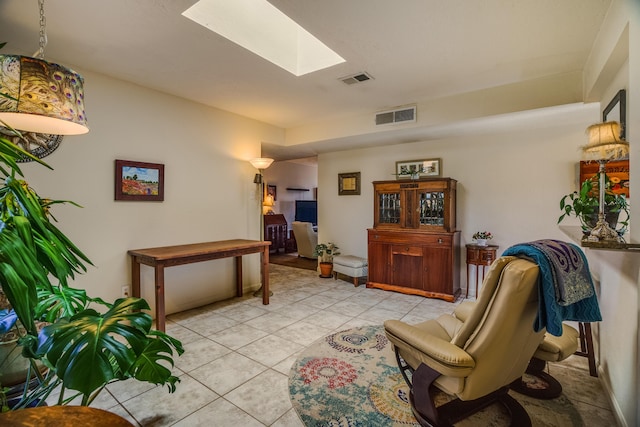 sitting room featuring light tile patterned floors, visible vents, and a skylight