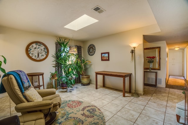 sitting room with visible vents, baseboards, a skylight, and light tile patterned flooring