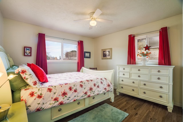 bedroom with ceiling fan, a textured ceiling, and dark wood-style floors