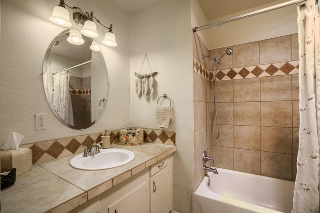 bathroom with vanity, a textured wall, and shower / bath combo with shower curtain