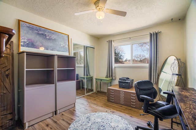 office with a ceiling fan, wood finished floors, and a textured ceiling