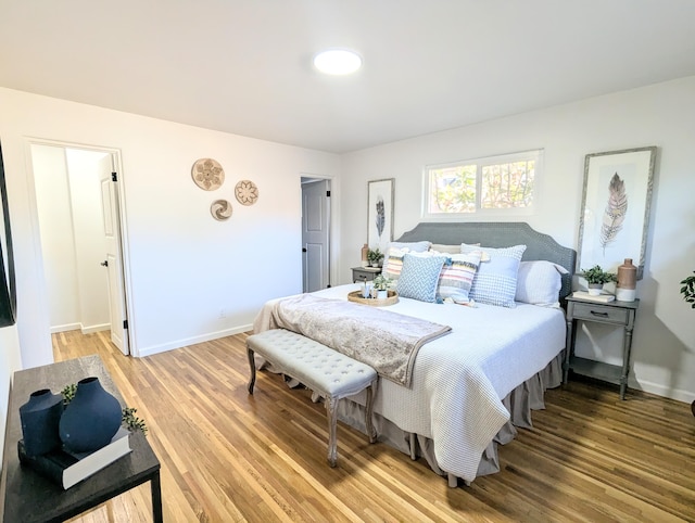 bedroom with light wood-type flooring and baseboards