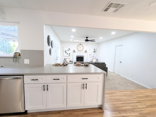 kitchen with visible vents, a peninsula, white cabinetry, a ceiling fan, and stainless steel dishwasher