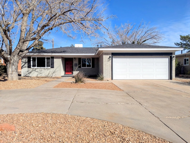 single story home featuring brick siding, an attached garage, and driveway