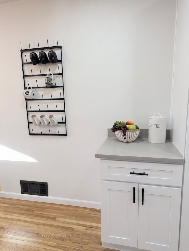 interior details featuring visible vents, baseboards, and wood finished floors