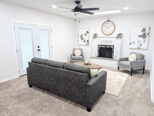 carpeted living room featuring a brick fireplace, recessed lighting, a ceiling fan, and baseboards