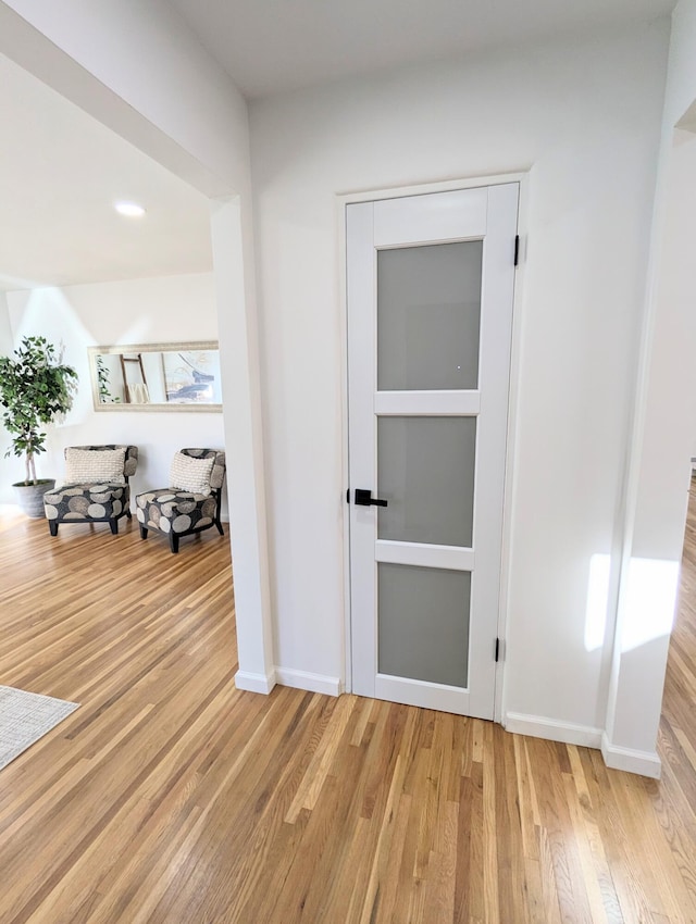 hall featuring baseboards and wood finished floors