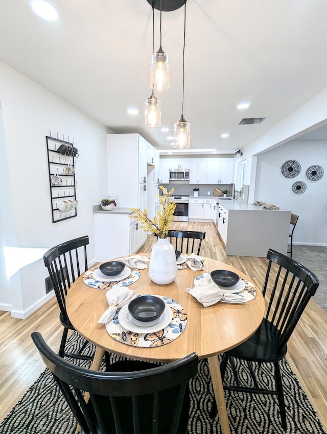 dining room featuring recessed lighting, visible vents, baseboards, and light wood finished floors