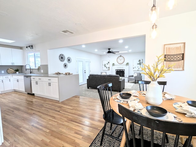 dining area with a ceiling fan, visible vents, recessed lighting, a fireplace, and light wood-type flooring