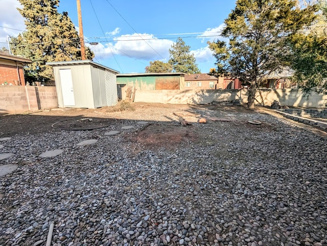 view of yard with a storage unit, a fenced backyard, and an outdoor structure