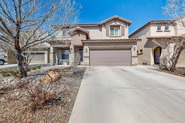 mediterranean / spanish-style house with stucco siding, stone siding, concrete driveway, a garage, and a tiled roof