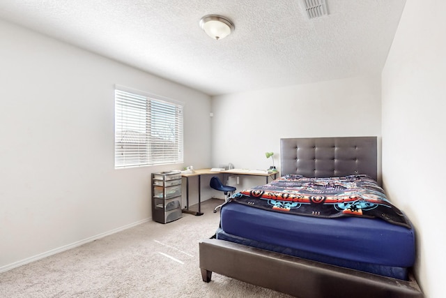 carpeted bedroom with visible vents, baseboards, and a textured ceiling