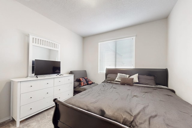 bedroom with light carpet and a textured ceiling