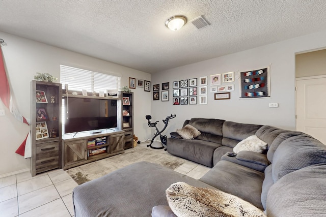 living room featuring visible vents, a textured ceiling, and light tile patterned flooring