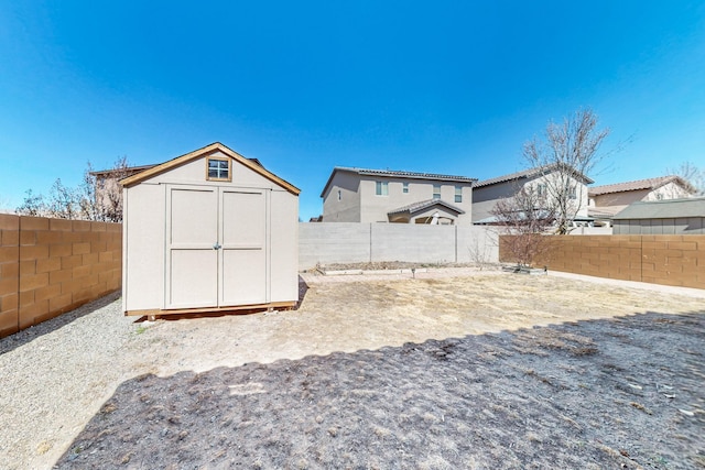 view of yard with an outbuilding, a fenced backyard, and a shed