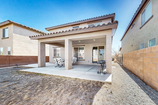 rear view of property featuring stucco siding, a patio, and a fenced backyard