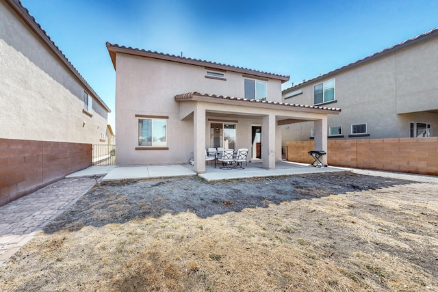 back of property with stucco siding, a patio area, and fence