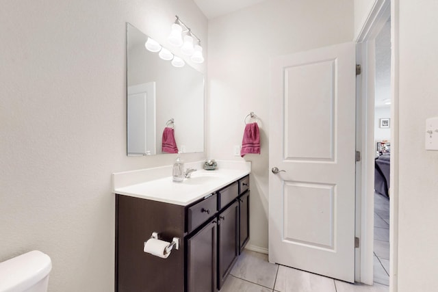 half bathroom featuring tile patterned floors, toilet, and vanity