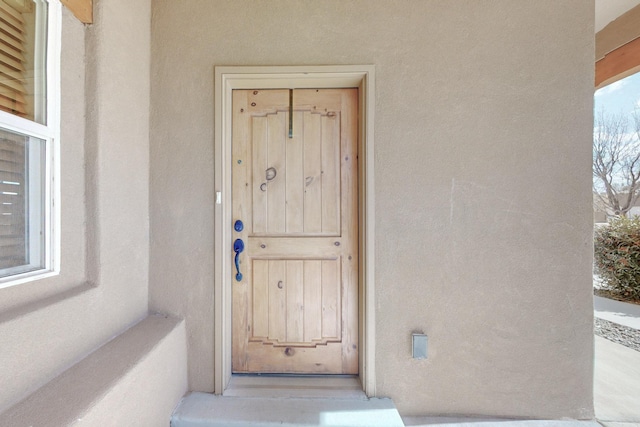 entrance to property featuring stucco siding