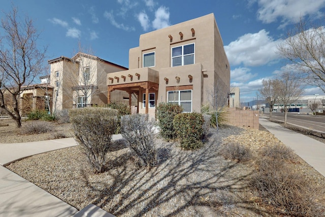 pueblo revival-style home featuring stucco siding