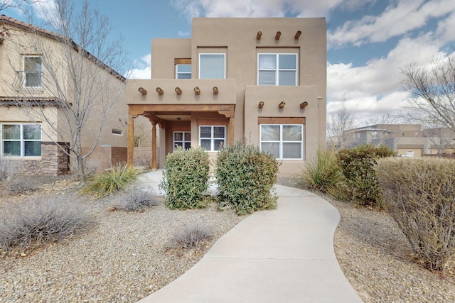 pueblo-style house featuring stucco siding