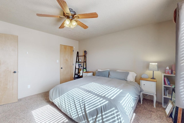 carpeted bedroom with ceiling fan and a textured ceiling