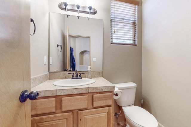 half bathroom with vanity and toilet