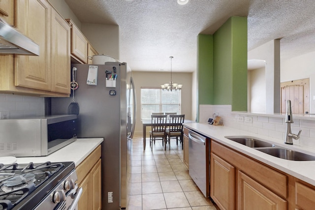 kitchen with light tile patterned floors, stainless steel appliances, light countertops, under cabinet range hood, and a sink