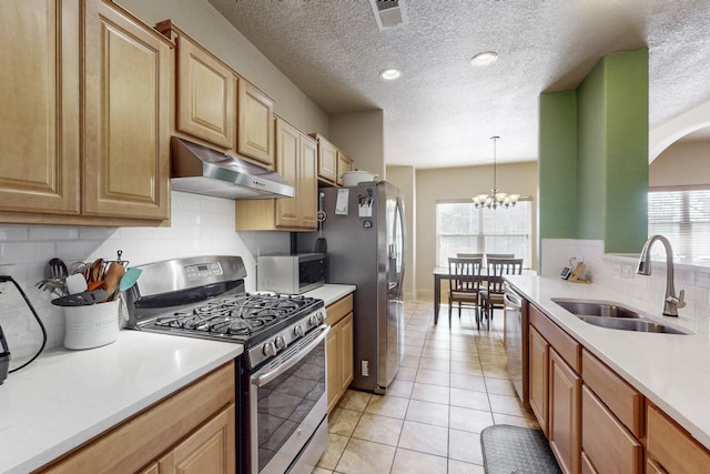 kitchen featuring under cabinet range hood, stainless steel appliances, a sink, visible vents, and light countertops