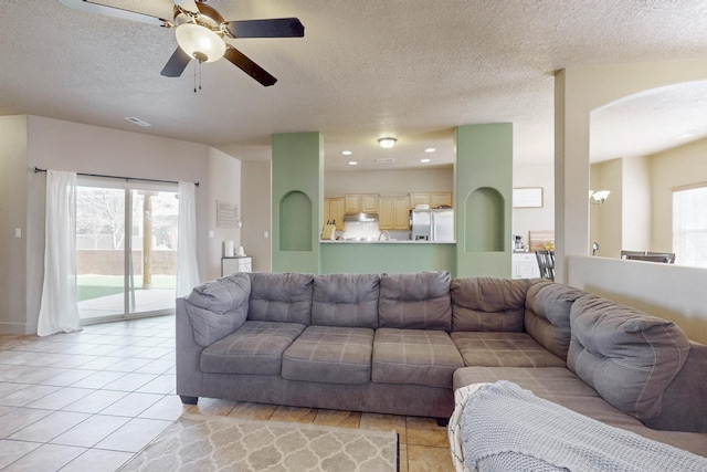 living area featuring light tile patterned floors, visible vents, a ceiling fan, a textured ceiling, and recessed lighting