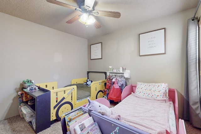 carpeted bedroom featuring a textured ceiling and a ceiling fan