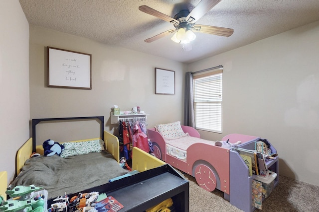 carpeted bedroom with a ceiling fan and a textured ceiling