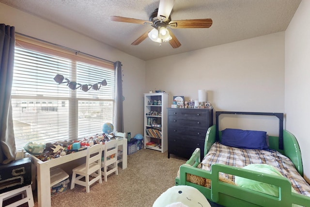 carpeted bedroom featuring a textured ceiling and ceiling fan